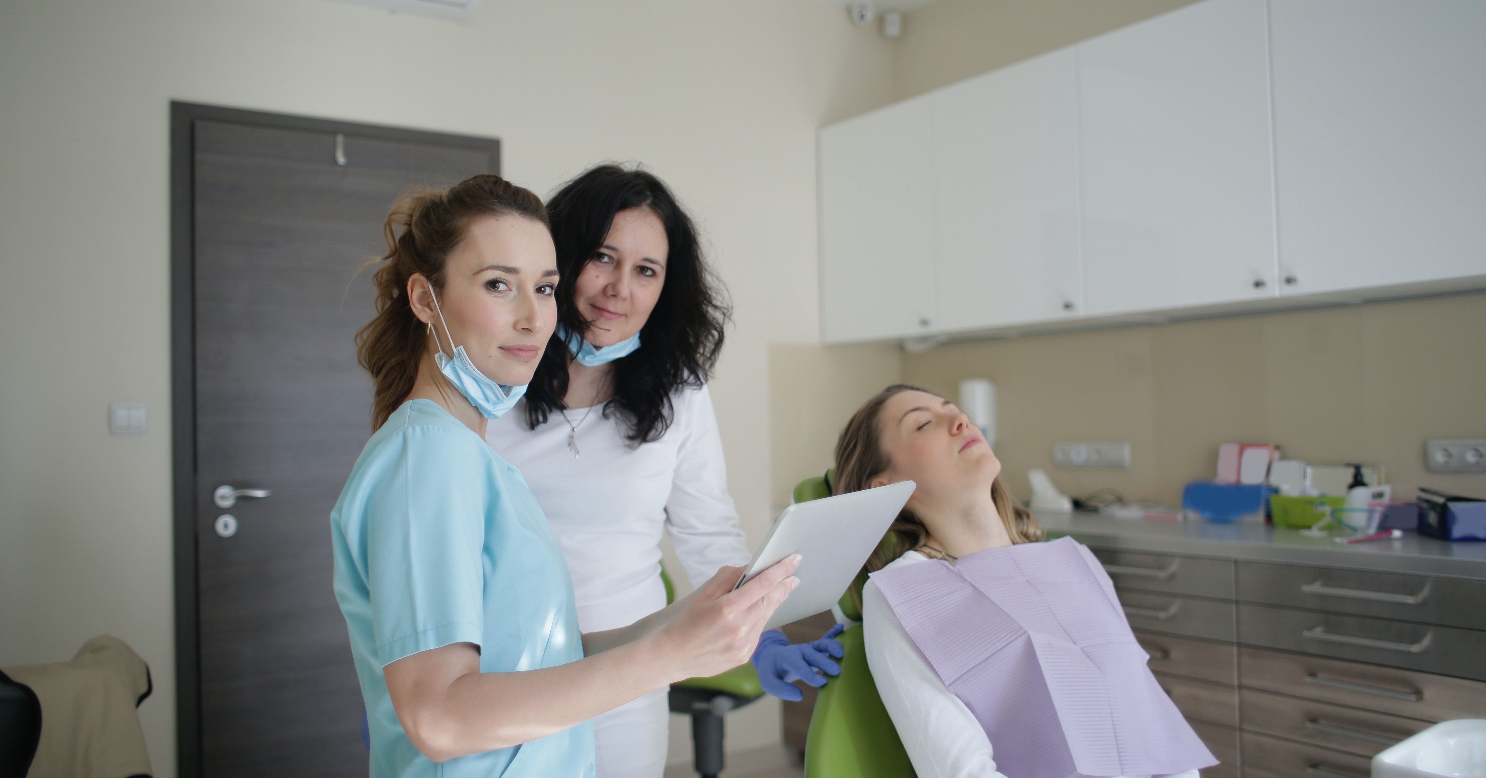 a group of dentists and a patient in an office