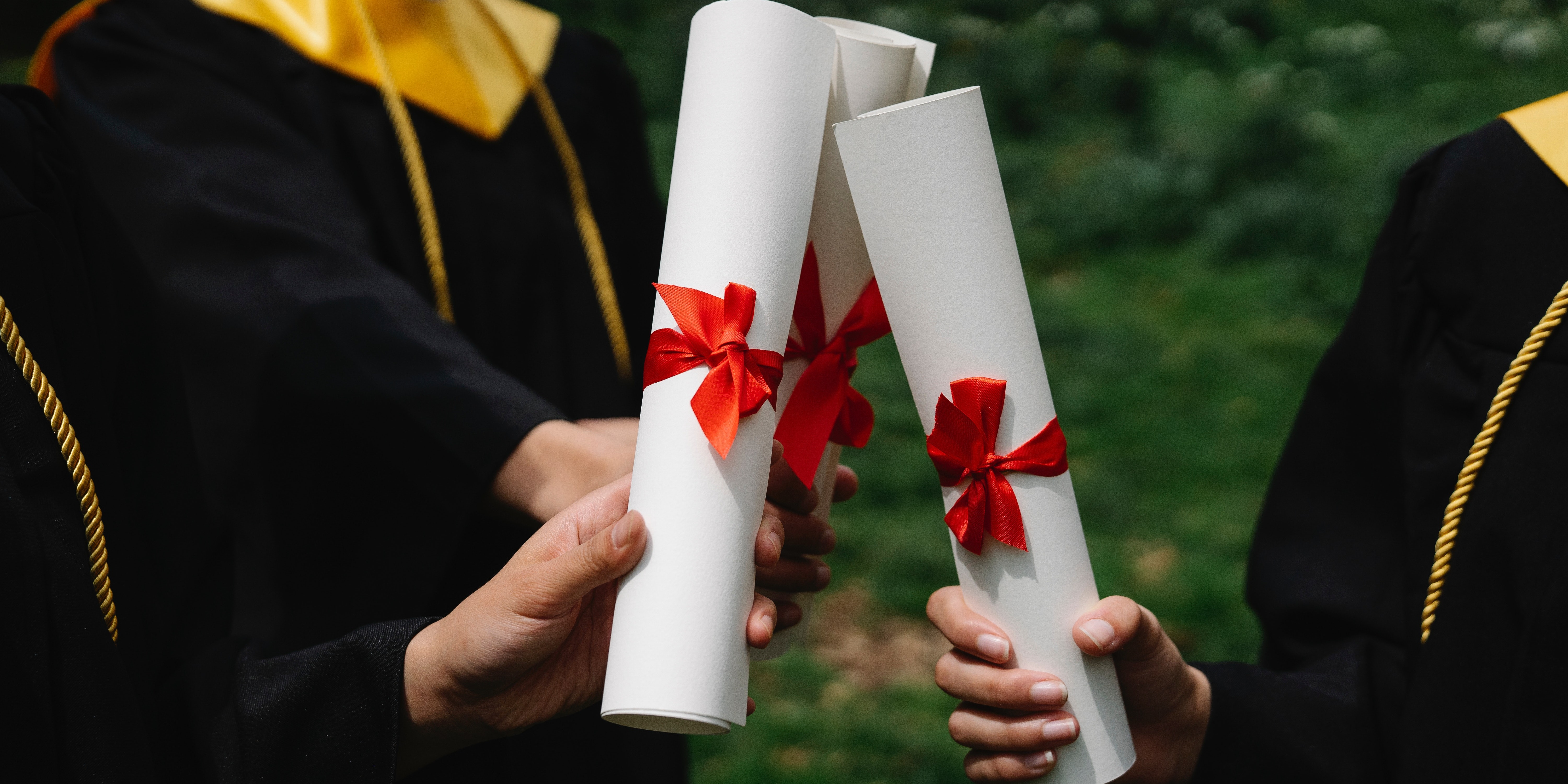 Photograph of People's Hands Holding White Diplomas